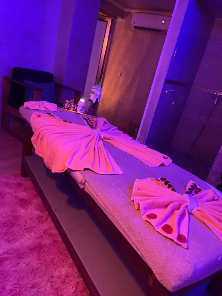 Table de massage décorée de pétales dans une cabine privée d’Arko Prestige Spa