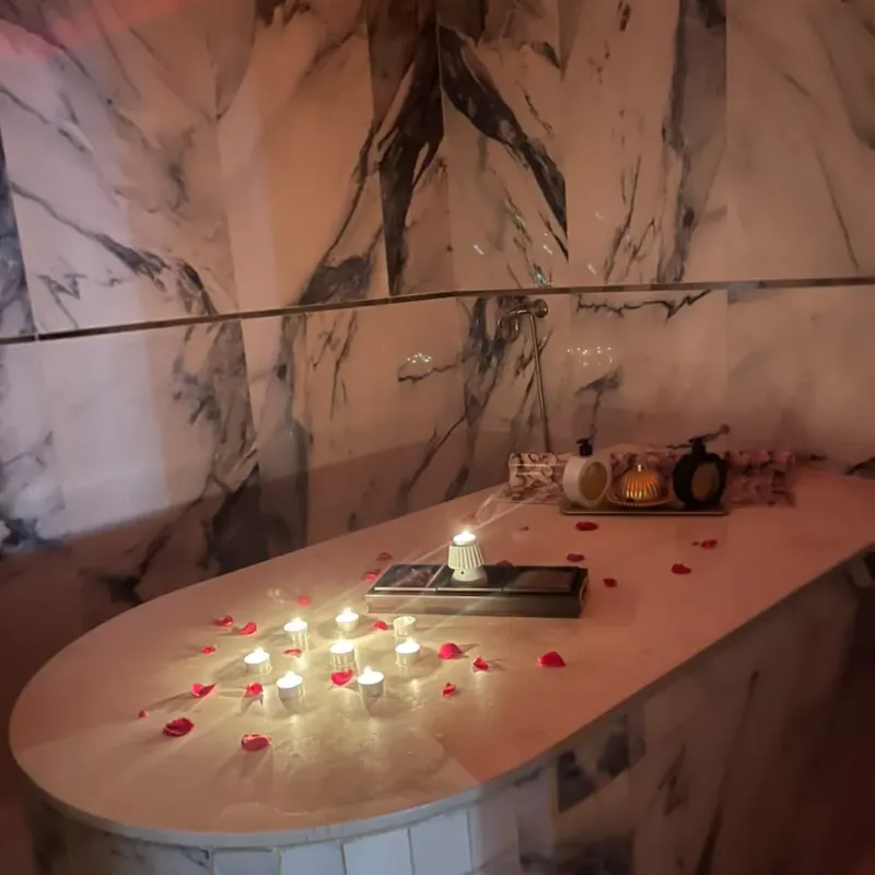 Candlelit marble hammam table scattered with rose petals at Arko Prestige Spa